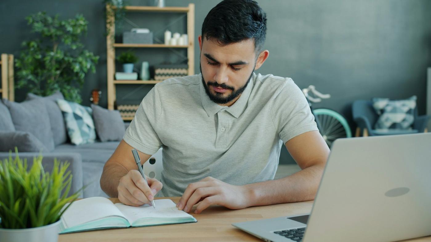 A man working through notes at his desk